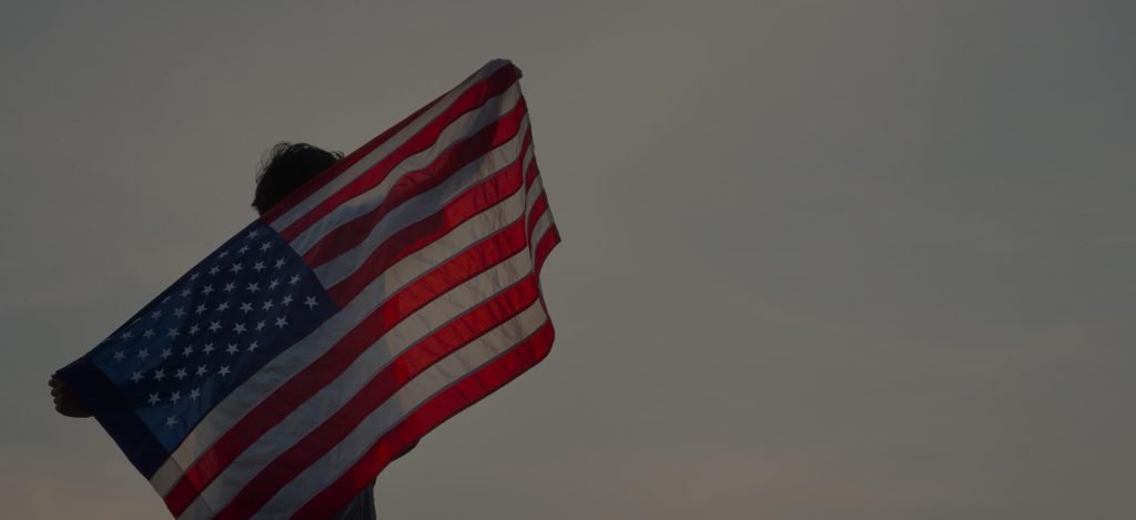 man holding a US flag on his back