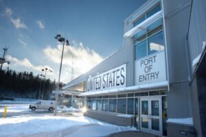 A building with "UNITED STATES PORT OF ENTRY" signage in a snowy landscape