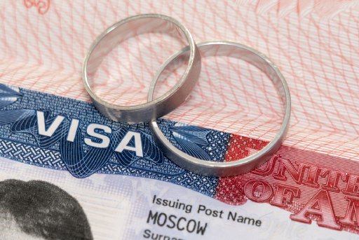 Newlyweds rings on a US visa close-up as an idea of marriage relocation