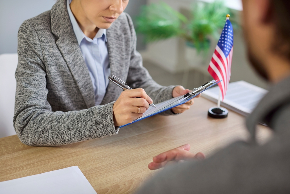 Consular visa interview with USA officer reviewing documents in public services or embassy