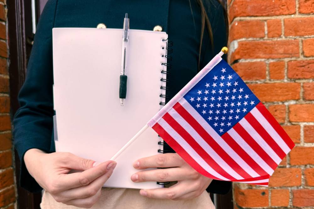 Woman with US flag and passport, symbol of travel, visa and immigration process.
