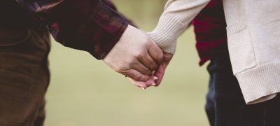 Closeup shot of a couple holding hands with a blurred background A closeup shot of a couple holding hands with a blurred background